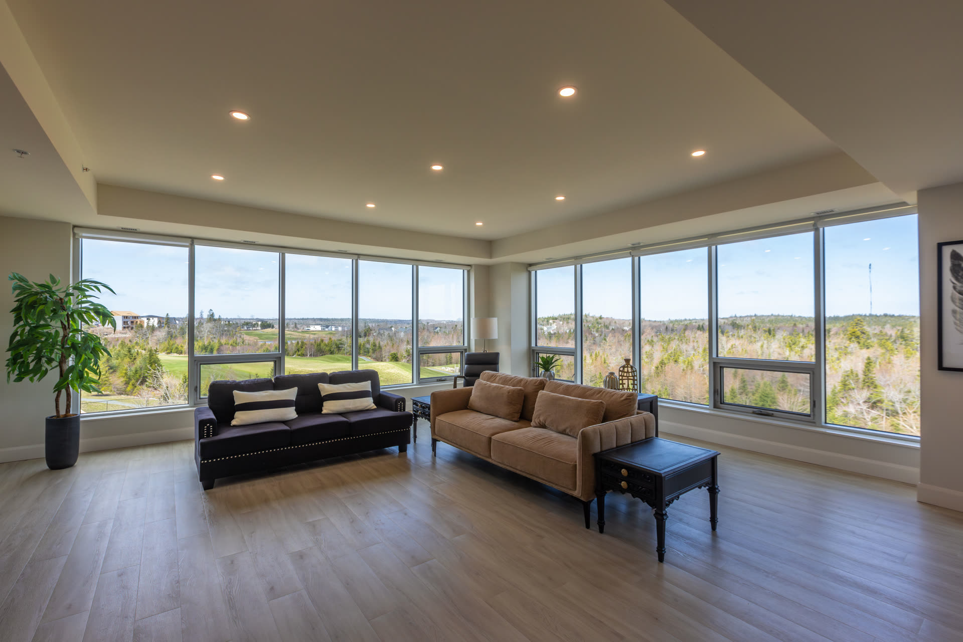 Social lounge with floor-to-ceiling windows overlooking the golf course and landscape.